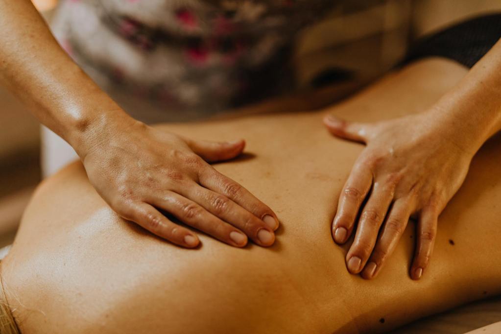 a close up shot of a masseues massaging a person s back